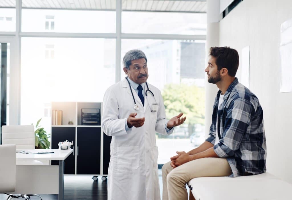 a man in a white coat talking to a doctor about prostate health - could Boron be a natural answer?