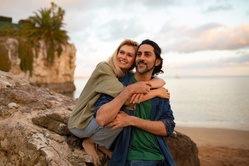 a man and woman hugging on a rock by the water. Is Tongkat Ali the source of his long lost libido?