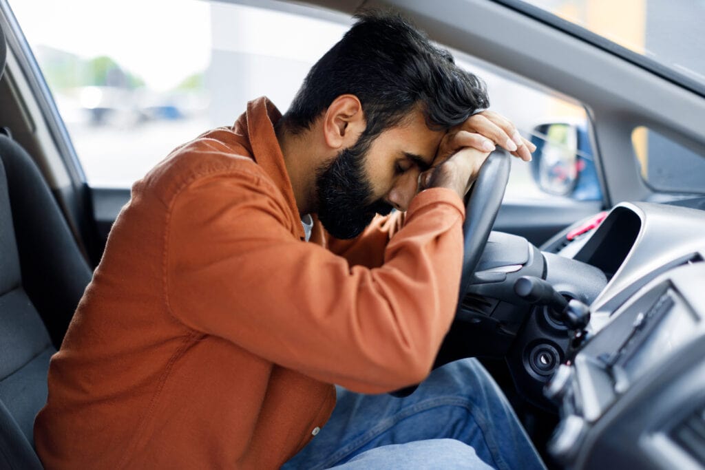 Young Man stressed in his car looking tired. Is Ashwagandha a natural answer?