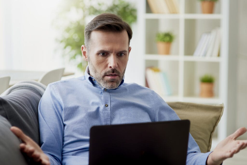 a man sitting in a chair looking at a laptop, stressed, tired. Could Boron be his answer to power up his cognitive function?