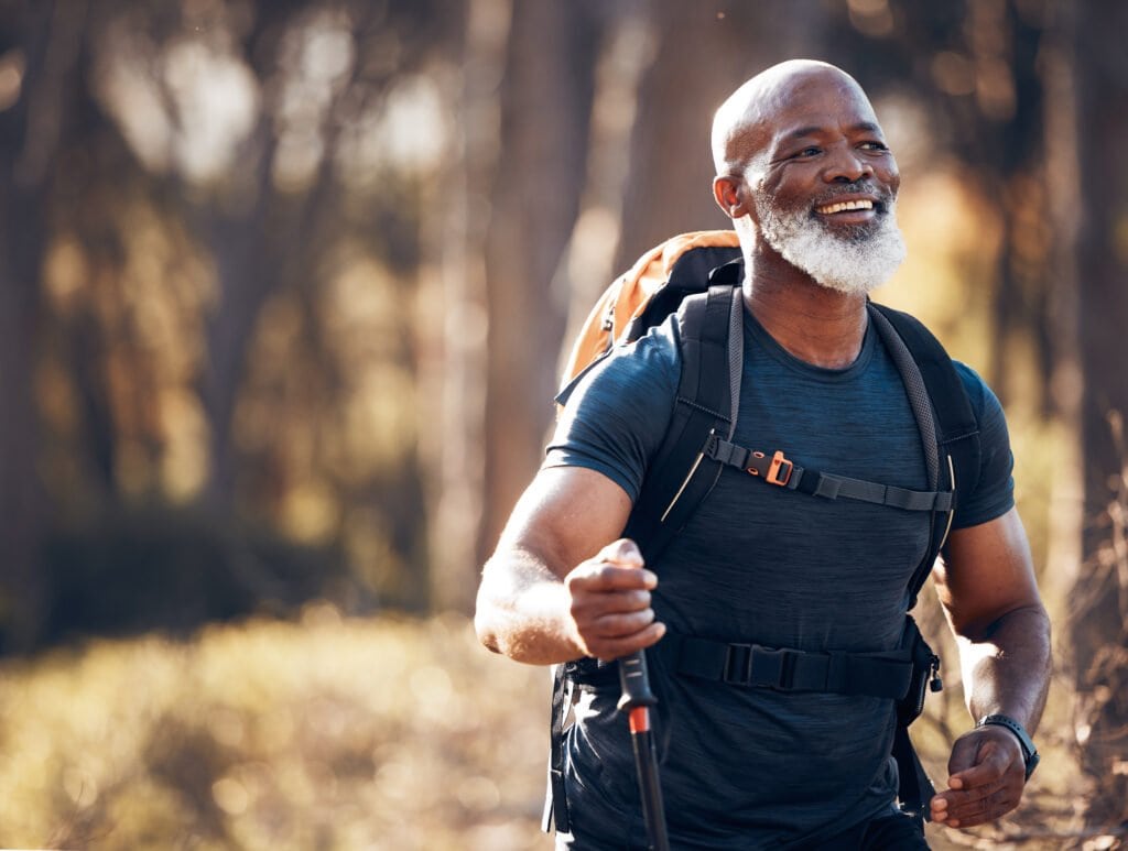 Older fit man hiking and smiling - Is Tonkgat Ali his secrete to maintaining performance goals?