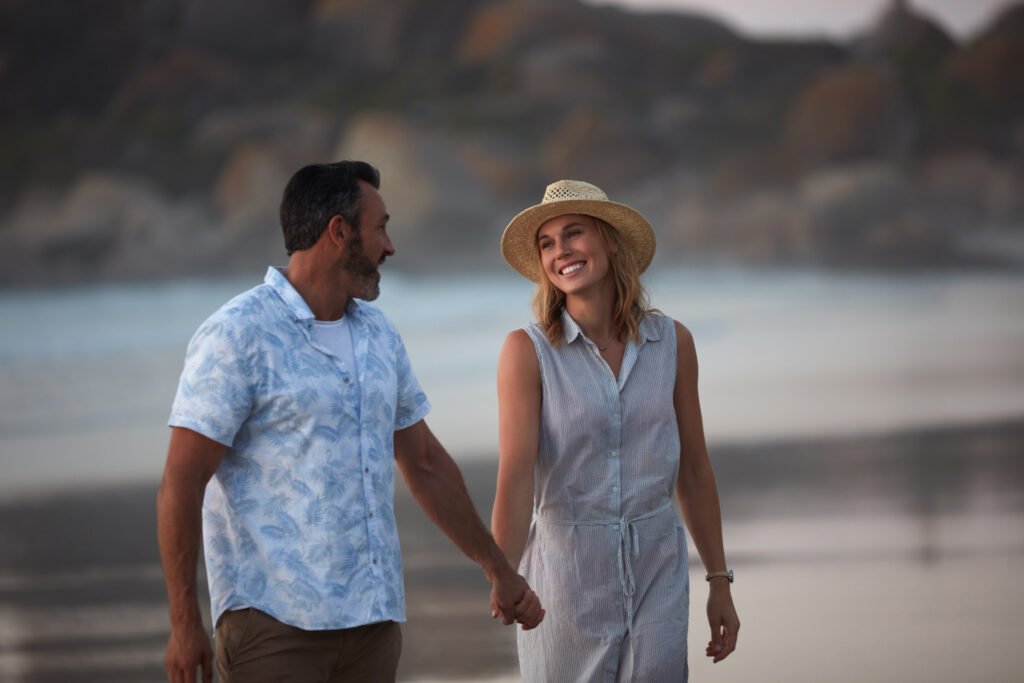 Affectionate couple holding hands on the beach - is Saw Palmetto his source for boosted Libido?