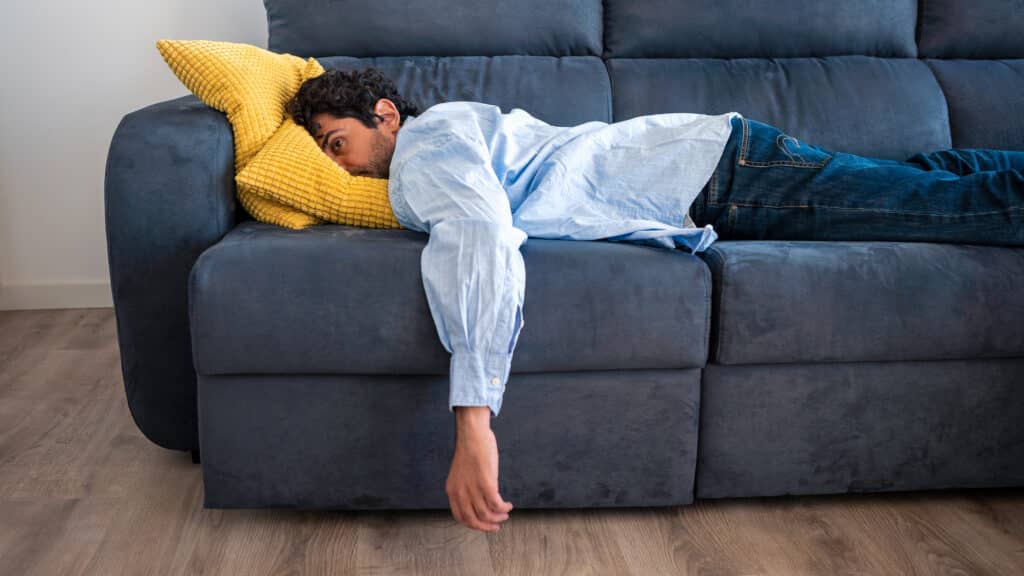 Man struggling to sleep on couch. Could he benefit from chamomile supplements?