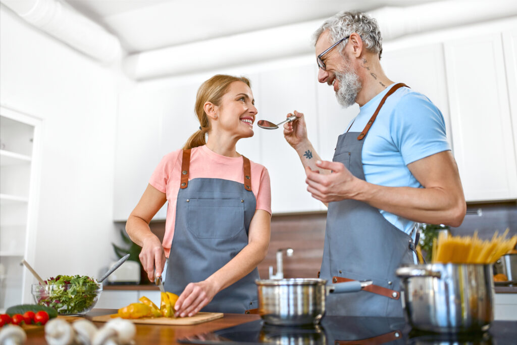 a man and woman cook happily in kitchen - is black pepper more than just a spice?