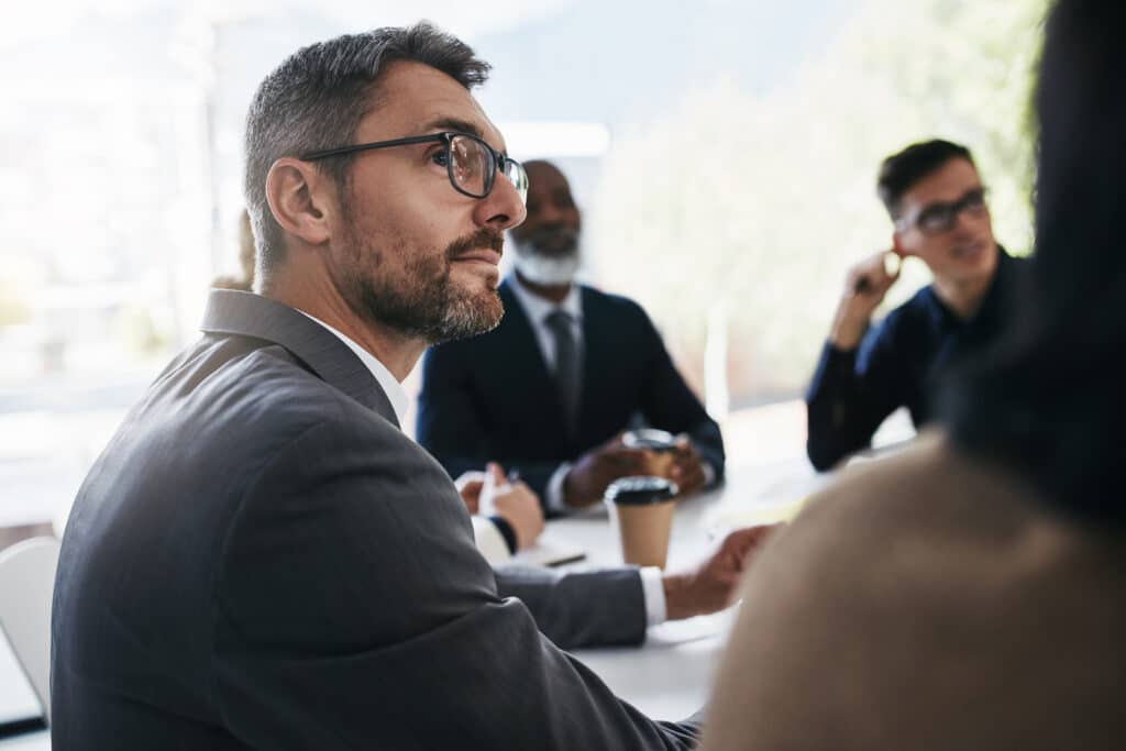 Man listening intently at a meeting - mentally fit as he has been sleeping well with melatonin for maximum cognitive health