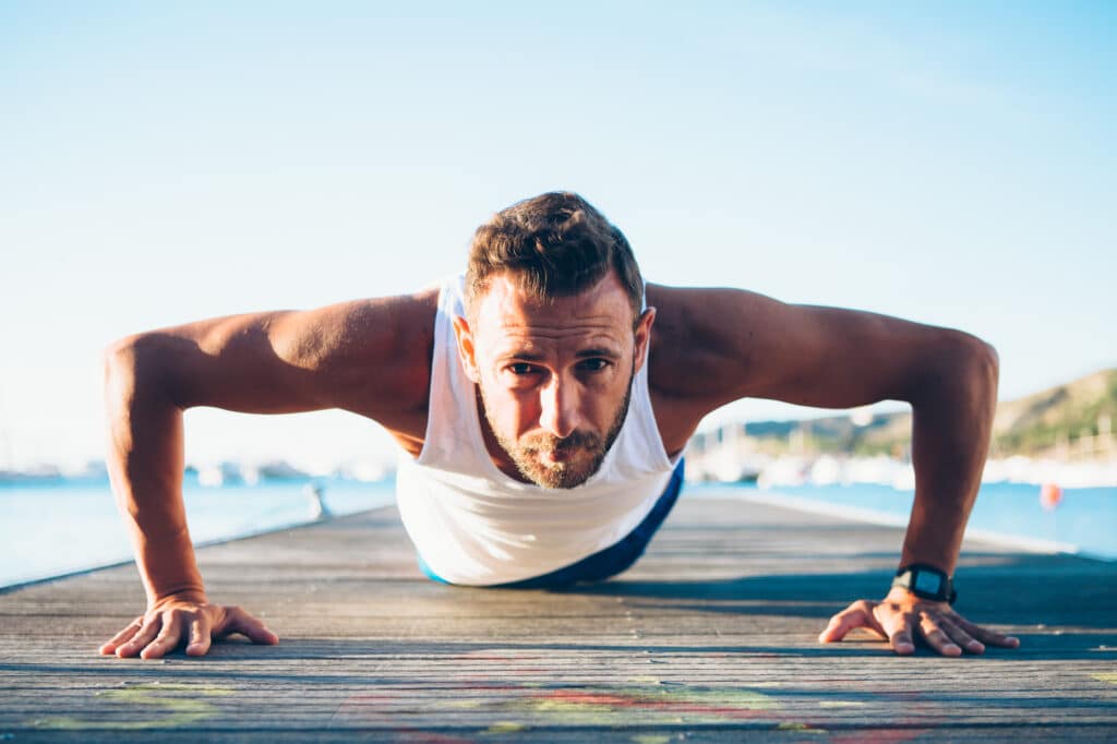 Fit man doing pushups outside. How to Increase Muscle Mass and Strength with Fenugreek