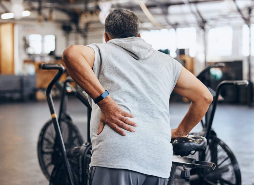 A man at the gym holding his back - could supplementing with Passion Flower help with muscle strain management