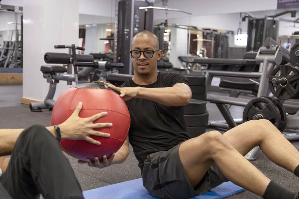 Man exercising with medicine ball due to taking best ashwagandha for testosterone