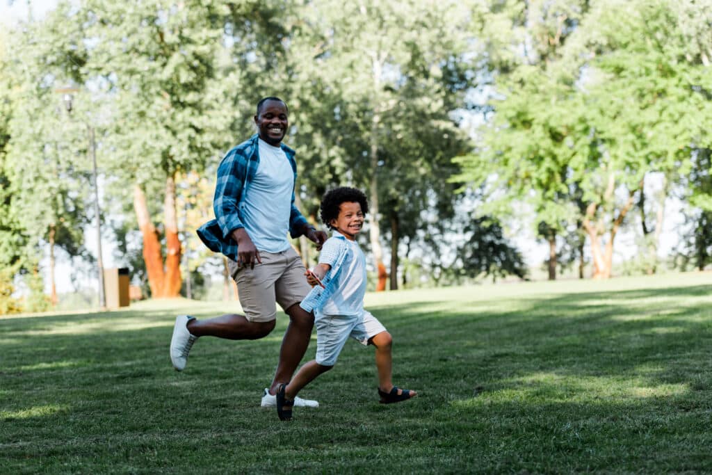 a man and boy running in a park on a sunny day with max energy - When the father was deciding between Ashwaganda vs Ginseng, for keeping up with his kids he wanted to know the benefits of each