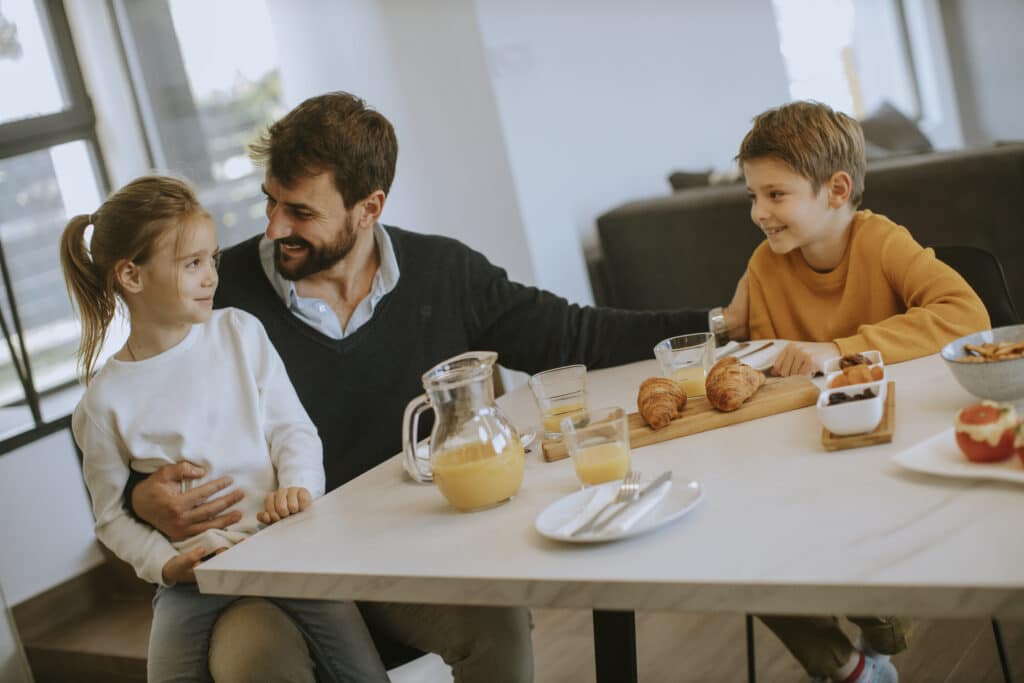 Dad having breakfast with son and daughter after having good sleep health and waking up refreshed.